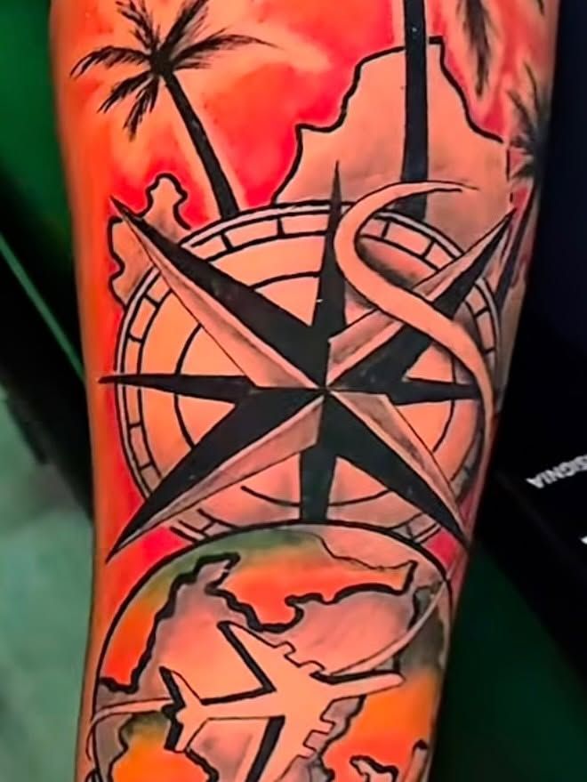 Color tattoo of a compass rose with palm trees, a world map and an airplane on a bright red-orange background.